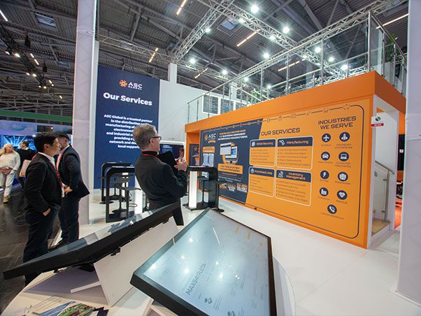 asc_global_electronica_2024_01 Image of ASC Global's booth featuring a giant print that highlights the company's services, the industries it serves, and its new components marketplace