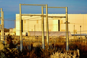 PJM Interconnection data center capacity management concept featuring large-scale data centers and an electricity grid, symbolizing demand growth, capacity shortfalls, emergency load reductions, and a proposed framework for managing new data center connections after 2027.